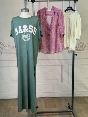 three shirts hanging on a clothes rack in a room