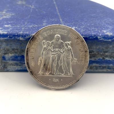 une image représentant une pièce d'argent posée sur un livre bleu