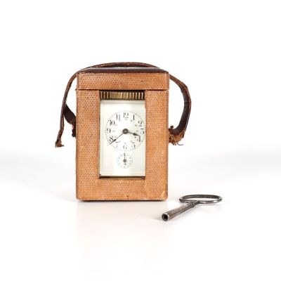 une petite horloge posée à côté d'une paire de ciseaux