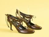 une paire de chaussures marron à lacets sur fond jaune
