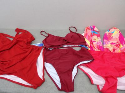 three women ' s swimsuits are lined up on a bed
