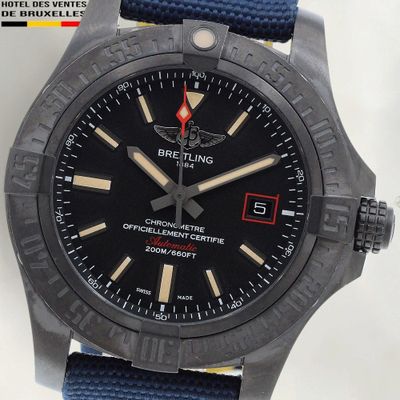 une montre noire avec un bracelet bleu sur fond blanc