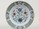 a plate with a floral design on it on a stand