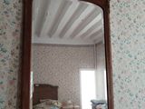 a mirror on a dresser in a room with a floral wallpapered wall