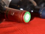 several bottles of wine are lined up on a red cloth