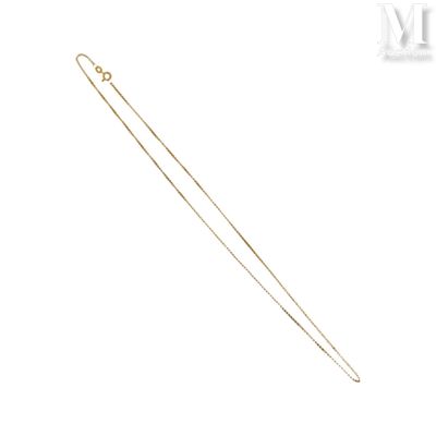 une image représentant un collier en or à longue chaîne sur fond blanc