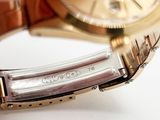 a close up of a person holding a gold wrist watch