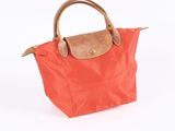 an orange purse with a brown handle on a white background