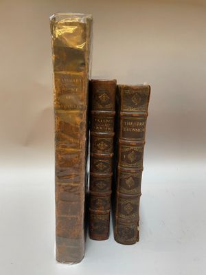 trois vieux livres posés l'un sur l'autre sur une table