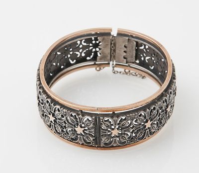 a silver and gold bracelet on a white background