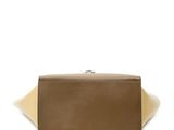 the large tan and beige bag is sitting on top of a white surface
