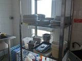 a kitchen with many dishes on the shelves and dishes on the counter