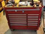 une boîte à outils rouge sur laquelle sont posés des outils, dans un garage