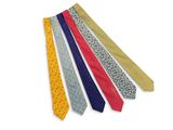 several different colored ties are arranged in a row on a white surface