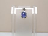 une photo d'un pendentif en saphir bleu et diamants, présenté dans une vitrine transparente