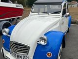 une petite voiture bleue et blanche garée sur un parking
