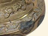 a close up of a brass plate with a bird on it