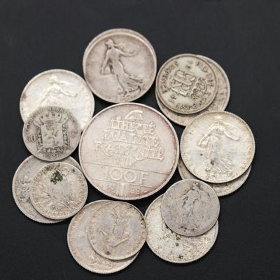 un tas de vieilles pièces de monnaie posées sur une surface noire