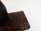 un bloc en bois sur lequel est représentée une horloge, posé sur une surface blanche