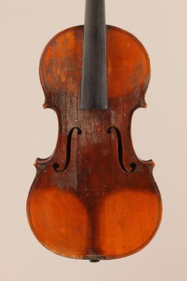 un vieux violon posé sur une surface blanche