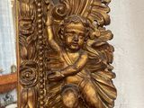 an image of a gold mirror with a statue of a man on it