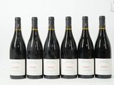 six bouteilles de vin sont alignées sur une surface blanche