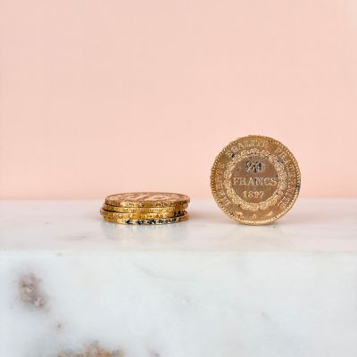 deux pièces d'or posées sur un comptoir en marbre