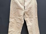 un vieux pantalon beige accroché à un mur noir