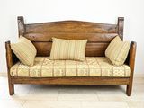 un banc en bois avec des coussins posé dans une pièce