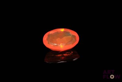 an orange diamond on a black surface with a black background