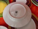 several plates and bowls are stacked on a table with a red table cloth