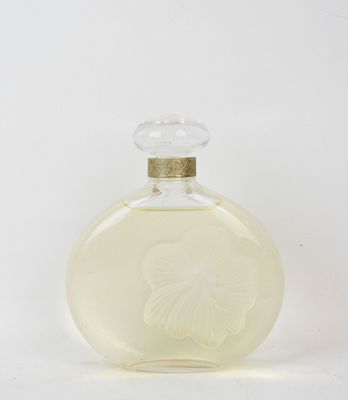 a small glass bottle with a white flower on it