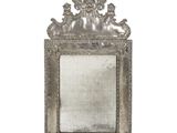 une image représentant un miroir à cadre argenté accroché à un mur blanc