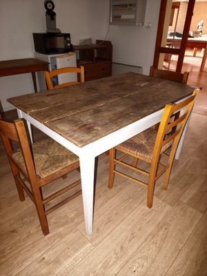 a table and chairs in a room with wood flooring