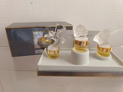 deux flacons de parfum posés sur un plateau, avec une boîte derrière eux