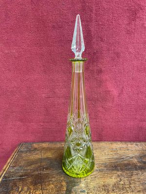une bouteille en verre vert posée sur une table en bois
