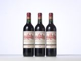 three bottles of red wine sitting on top of a table