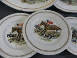 four plates with a picture of a horse and rider on them