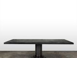 an image of a black table on a concrete floor with a white wall in the background