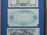 two old french bank notes in a wooden frame with a blue background