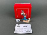 the figurine is sitting on the table next to a red box