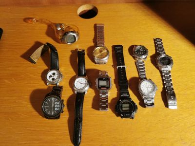 a lot of watches that are on a wooden table