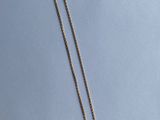 un collier avec une chaîne en or sur fond bleu