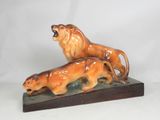 une figurine représentant un lion et son lionceau, posée sur un socle