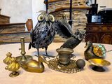 an owl statue sitting on top of a table next to other items