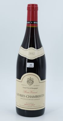 the bottle of wine is sitting on a white surface