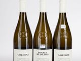 trois bouteilles de vin posées sur une table blanche