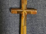 une croix en or suspendue à un cordon blanc sur un tissu bleu