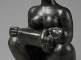 une statue noire représentant une femme tenant un bébé sur ses genoux