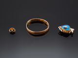 two gold rings and a ring with a blue stone